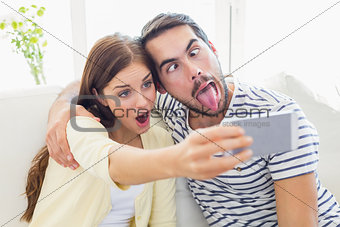 Cute couple taking a selfie on couch