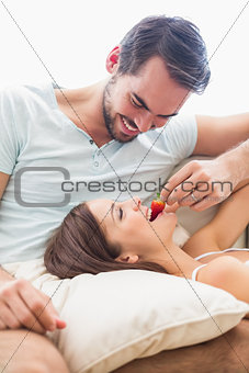 Man feeding his girlfriend a strawberry