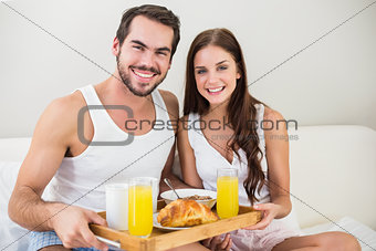Young couple having breakfast in bed