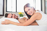 Young couple smiling at camera in bed