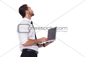 Sophisticated businessman standing using a laptop