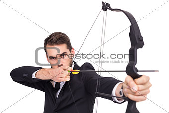 Smart businessman practicing archery looking at camera