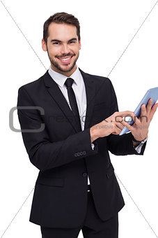 Businessman using his tablet while looking at the camera