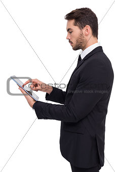 Concentrated businessman touching his tablet