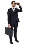 Businessman holding a briefcase while using binoculars