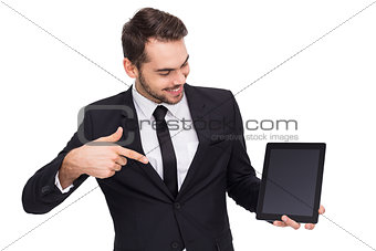 Happy businessman pointing with his tablet