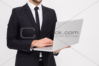 Mid section of a businessman using laptop