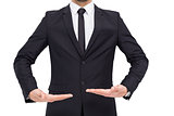 Mid section of a businessman holding something