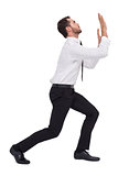 Businessman standing with bent legs and pushing