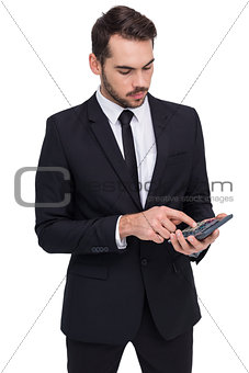 Concentrated businessman in suit using calculator