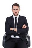 Serious businessman sitting with arms crossed