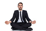 Peaceful businessman sitting in lotus pose relaxing
