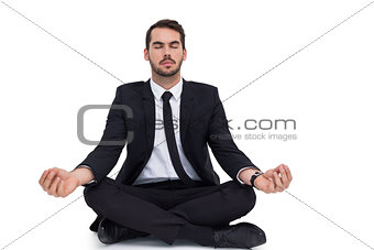 Peaceful businessman sitting in lotus pose relaxing