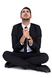 Businessman sitting praying and looking up