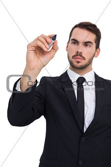 Thoughtful businessman writing with marker