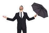 Happy businessman holding umbrella