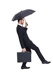 Businessman holding briefcase under umbrella