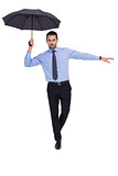 Concentrated businessman with umbrella balancing