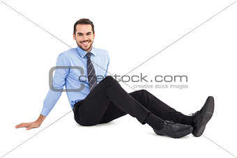 Happy businessman sitting on floor