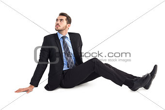 Businessman sitting on floor looking up