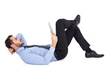 Businessman lying on floor using tablet