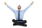 Businessman cheering with tablet sitting on floor