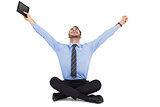 Businessman cheering and holding his tablet
