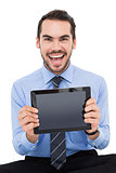 Happy businessman showing his tablet pc