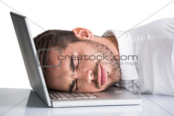 Cheerful businessman resting head on his laptop