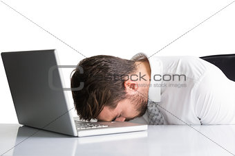 Exhausted businessman sleeping head on laptop