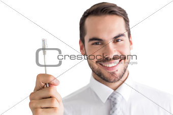 Happy businessman holding white cable