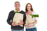Casual couple holding grocery bags
