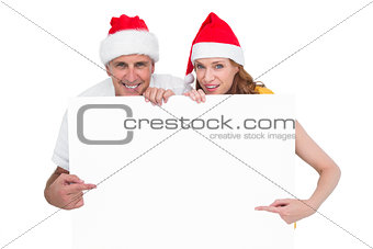 Festive couple showing a poster