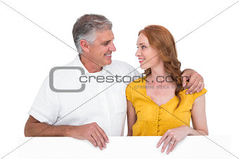 Casual couple showing a poster