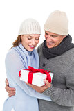 Casual couple in warm clothing holding gift
