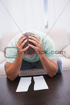 Worried man looking at ripped page