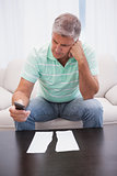 Worried man looking at ripped page sending a text