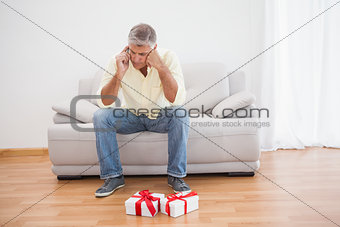 Man talking on phone looking at gifts