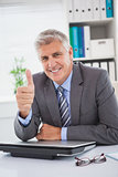 Smiling businessman showing thumbs up