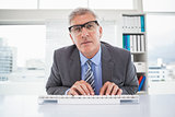Focused businessman typing at his desk