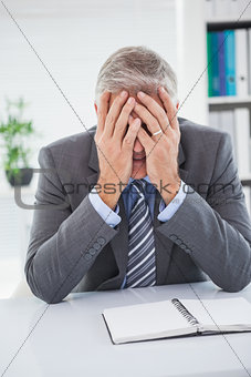 Stressed businessman covering his face