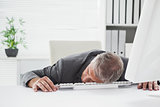 Exhausted businessman sleeping at his desk
