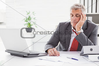 Tired businessman falling asleep at desk