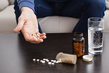 Man with his medicine laid out on coffee table