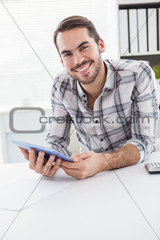 Casual businessman using tablet at desk