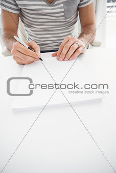 Casual businessman writing at his desk