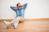 Casual man sitting on floor looking up