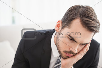 Worried businessman sitting on his couch