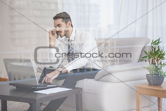 Businessman working on his couch seen through glass