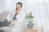 Businessman sitting on his couch seen through glass